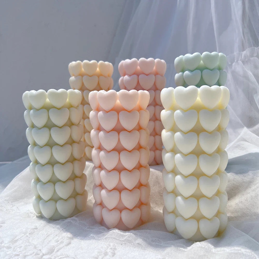 Heart-textured freestanding pillars in yellow, pink and mint wax