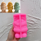 Pink silicone Santa Claus mold held in a hand beside finished candle samples