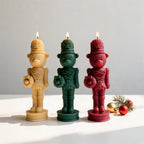 Cream, green and red bear nutcracker candles in a festive arrangement