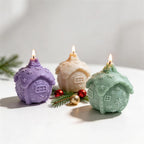 Rounded gingerbread cottage candles with snowflake roofs