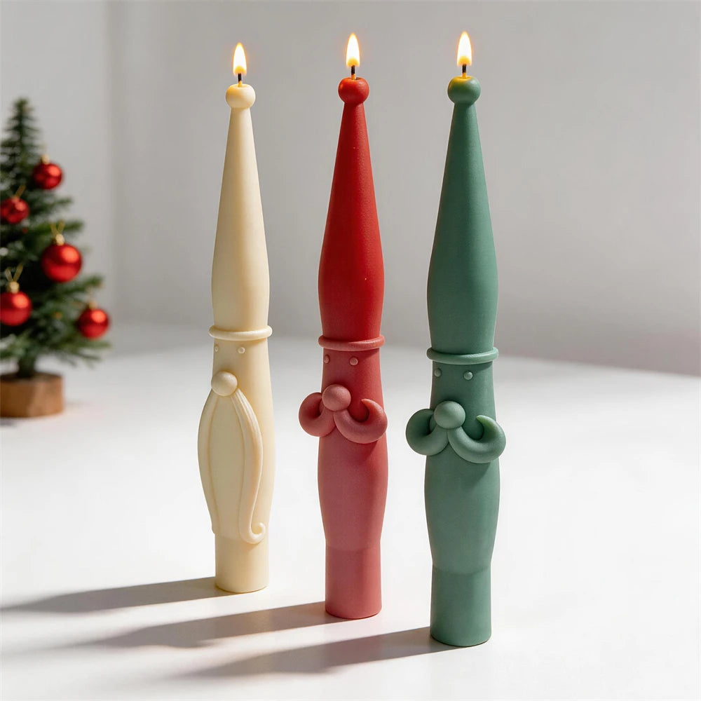 Three standing holiday tapers with lit wicks, including moustache and beard variants