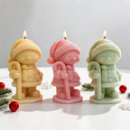 Angled view of winter hat figure candles with scarves and pom-poms