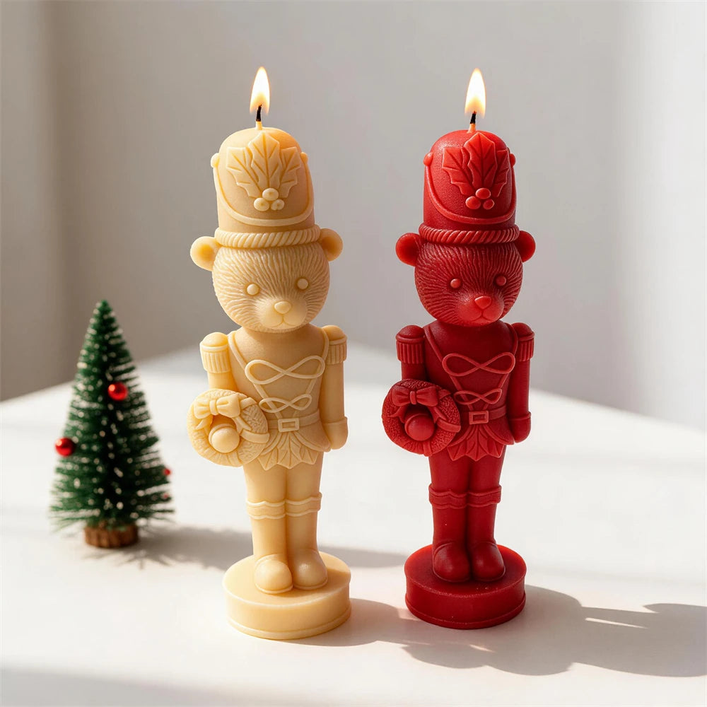 Cream and red bear nutcracker candles beside a miniature Christmas tree