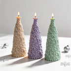 Three slender star topped tree candle samples on a white surface