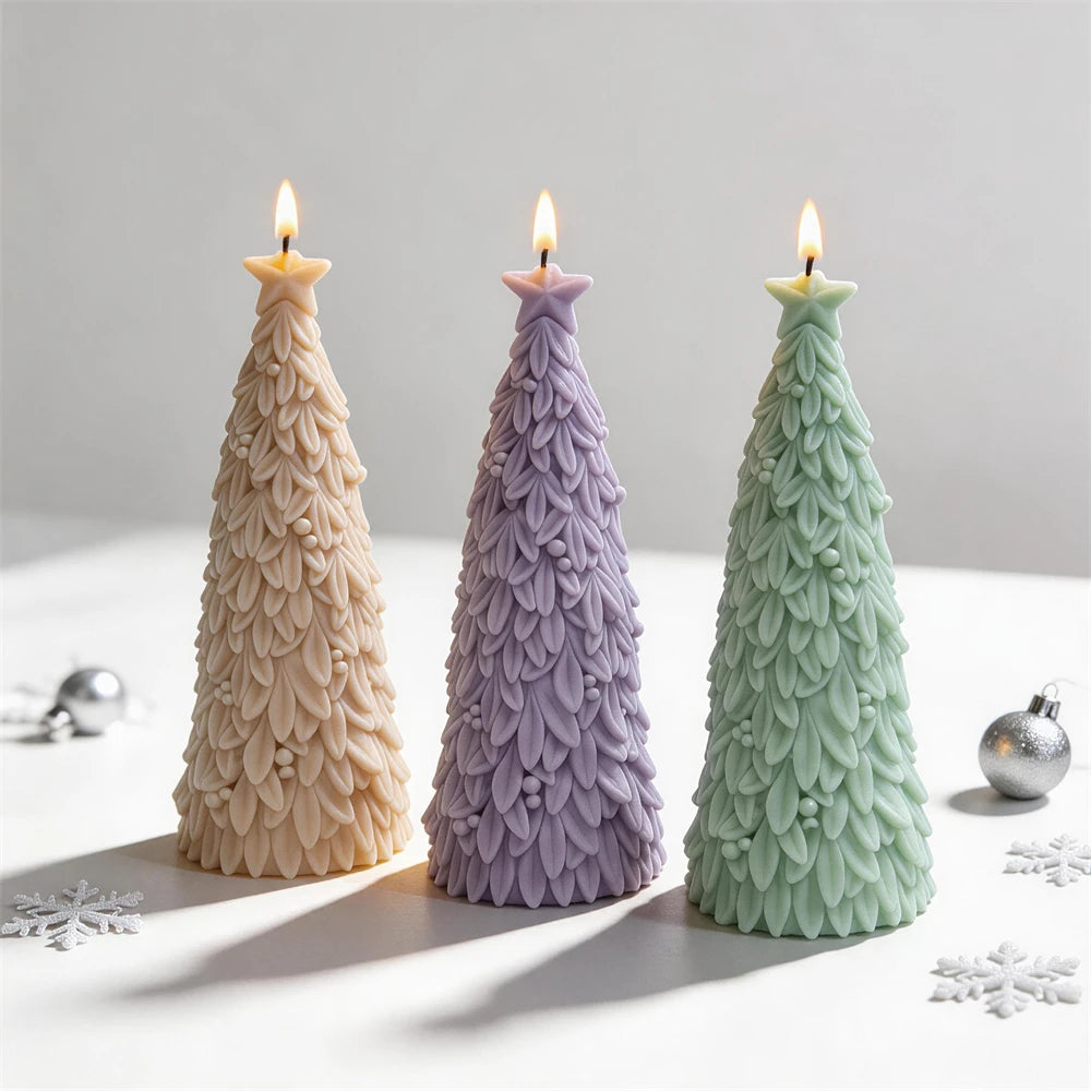 Three slender star topped tree candle samples on a white surface
