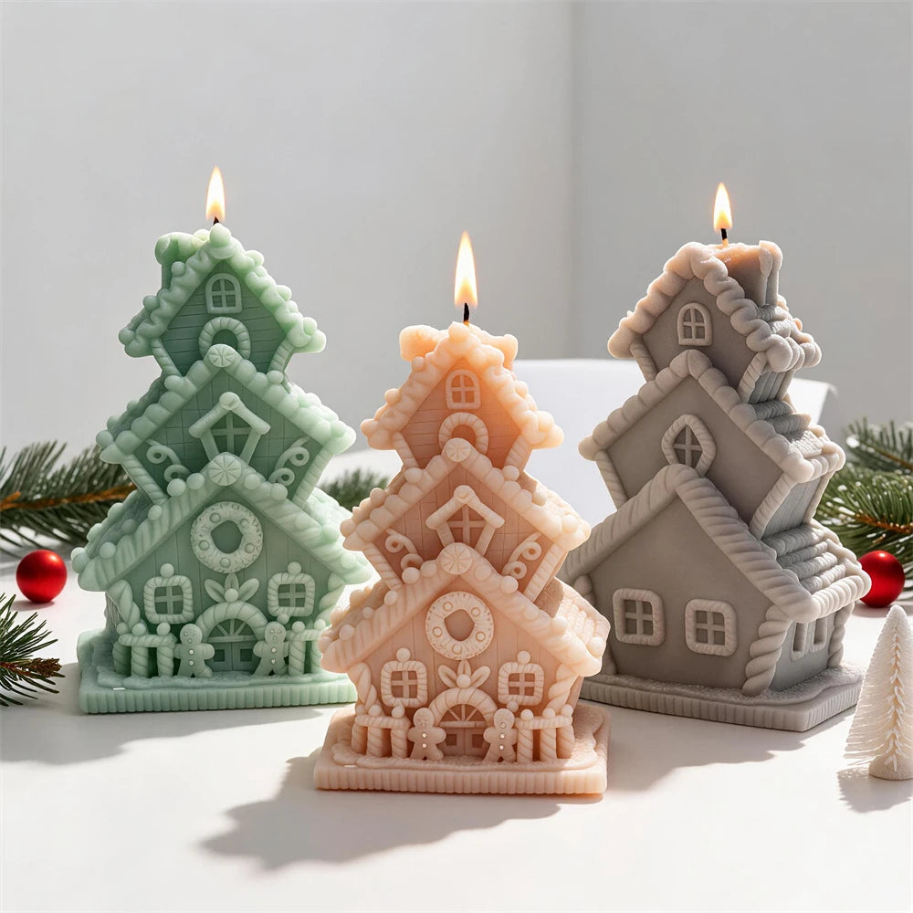 Three stacked gingerbread cottage candles with pitched roofs and icing-style trim