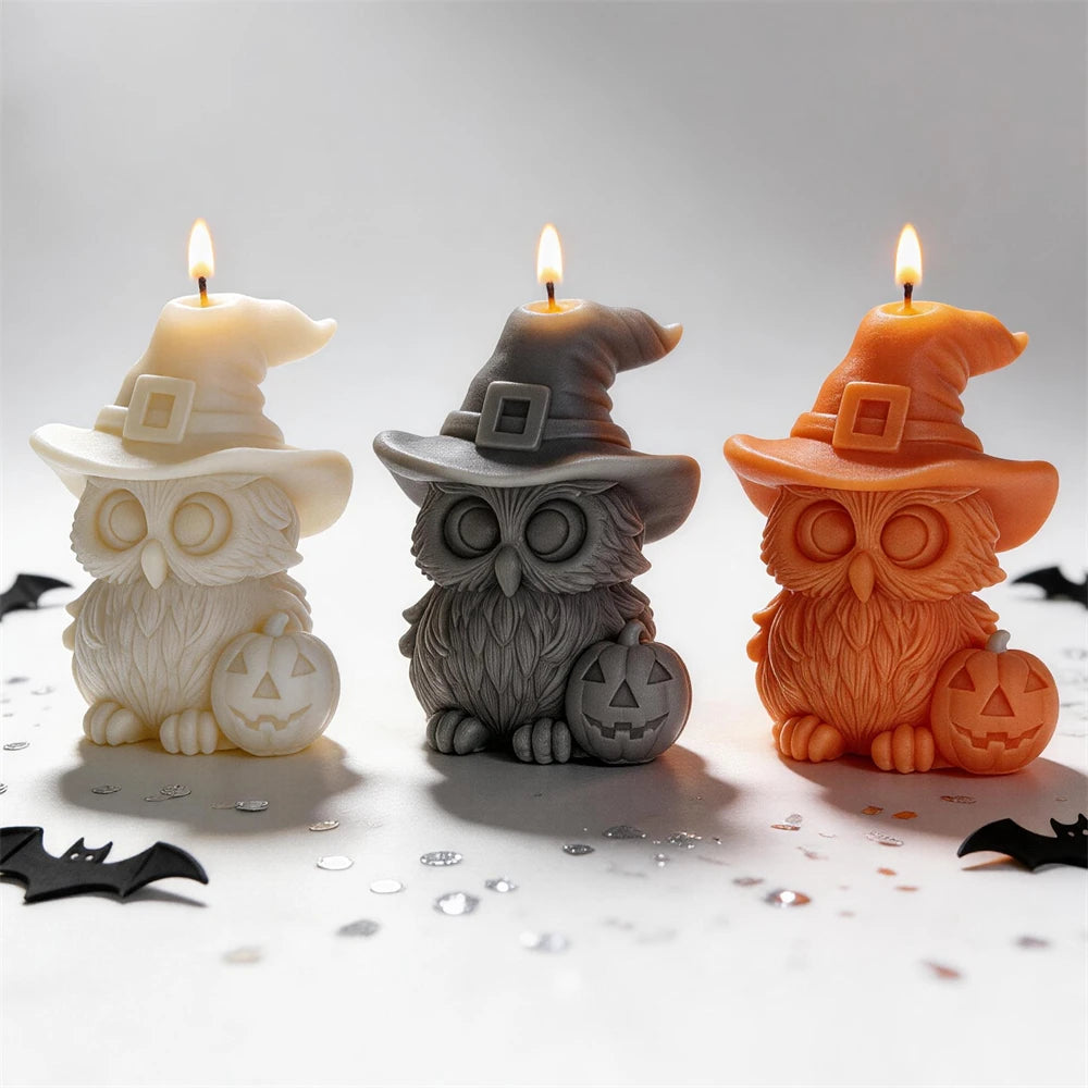 Cream black and orange owl candles wearing witch hats beside pumpkins