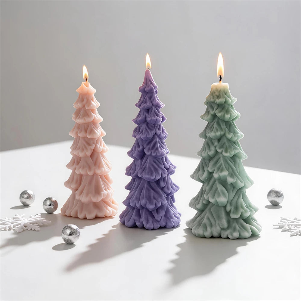 Three layered Christmas tree candles beside silver ornaments
