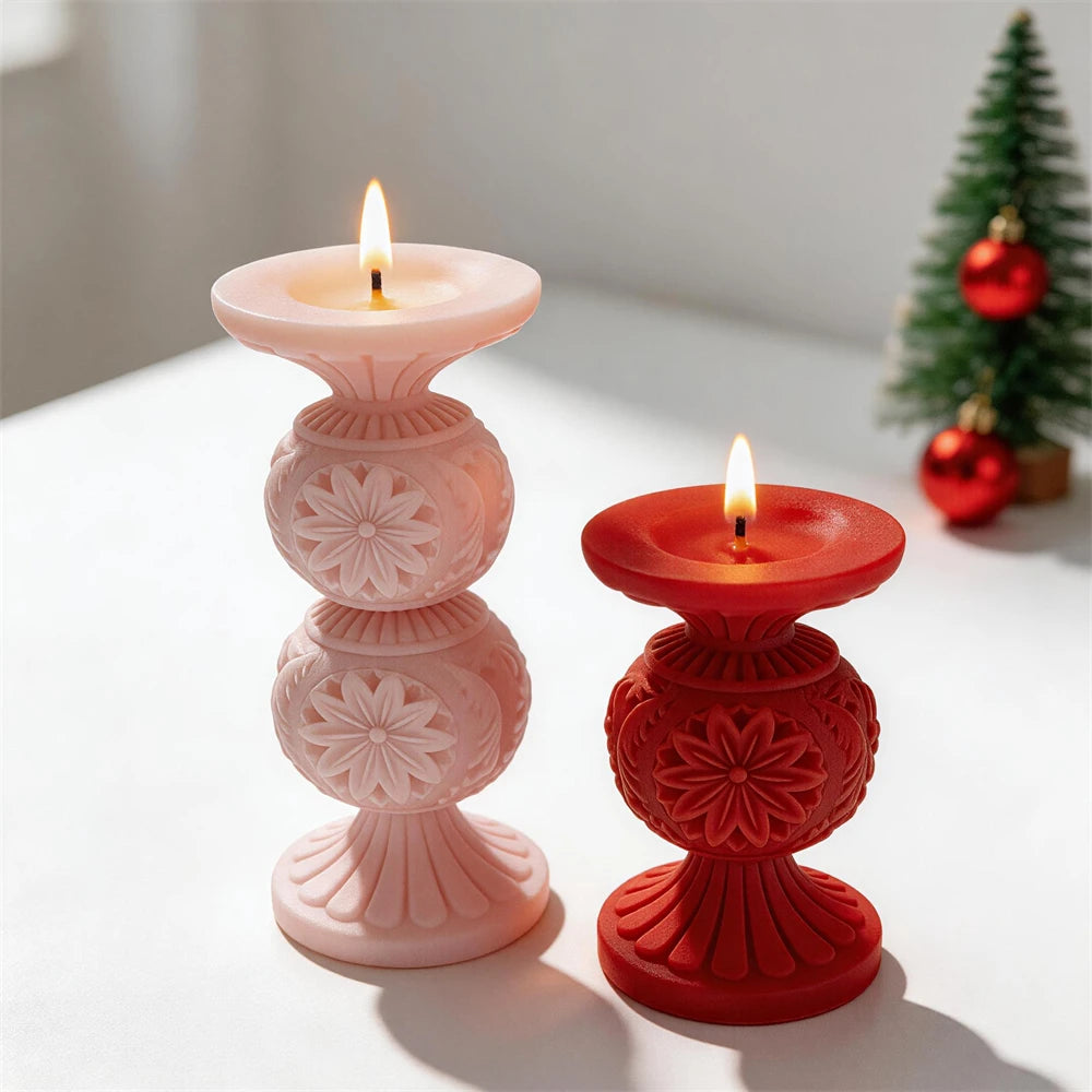 Pink double-globe and red single-globe snowflake candles beside a miniature Christmas tree