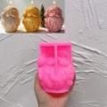 Pink silicone Santa face mold held beneath finished examples