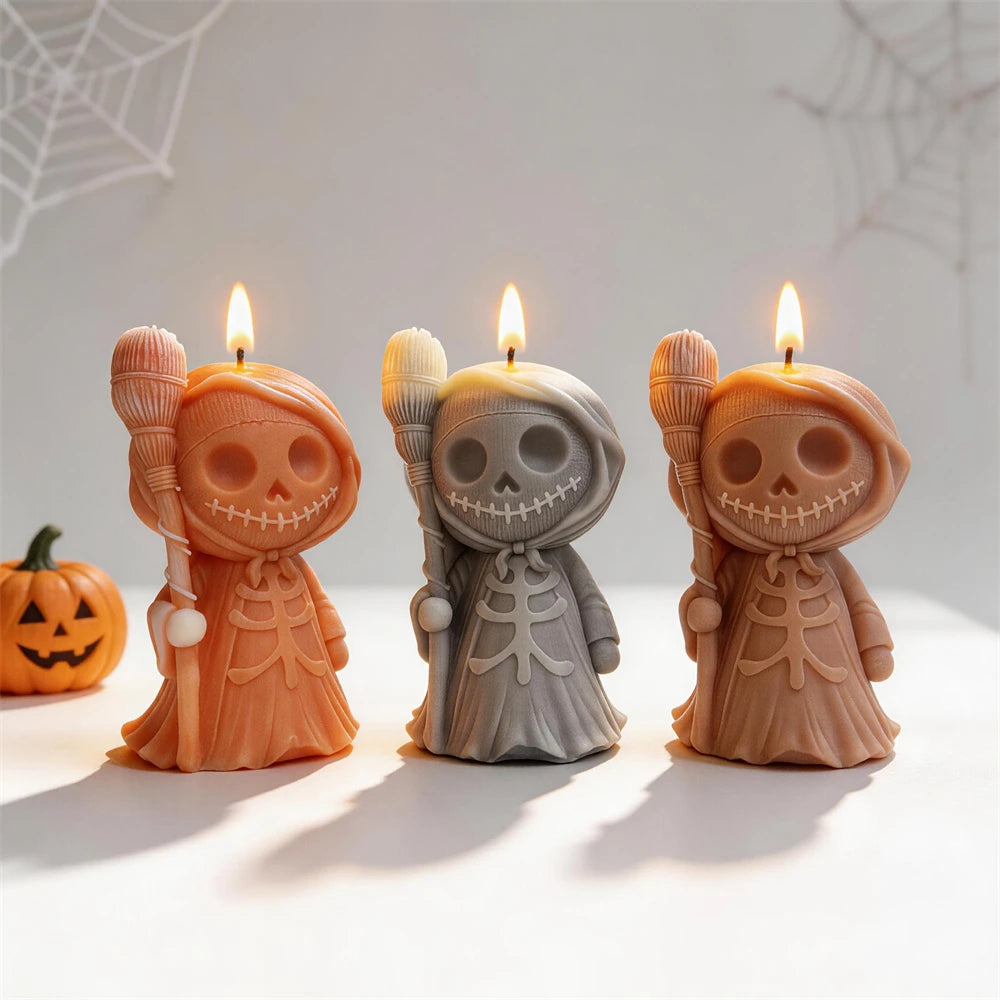 Three hooded skeleton candle figures holding brooms