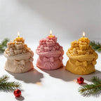 Cream pink and golden gift-sack candles styled with Christmas greenery