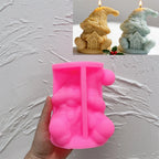 Pink silicone sitting gnome mold beneath finished candle examples