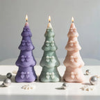 Lit tiered Christmas tree candles with ribbon bands and bows