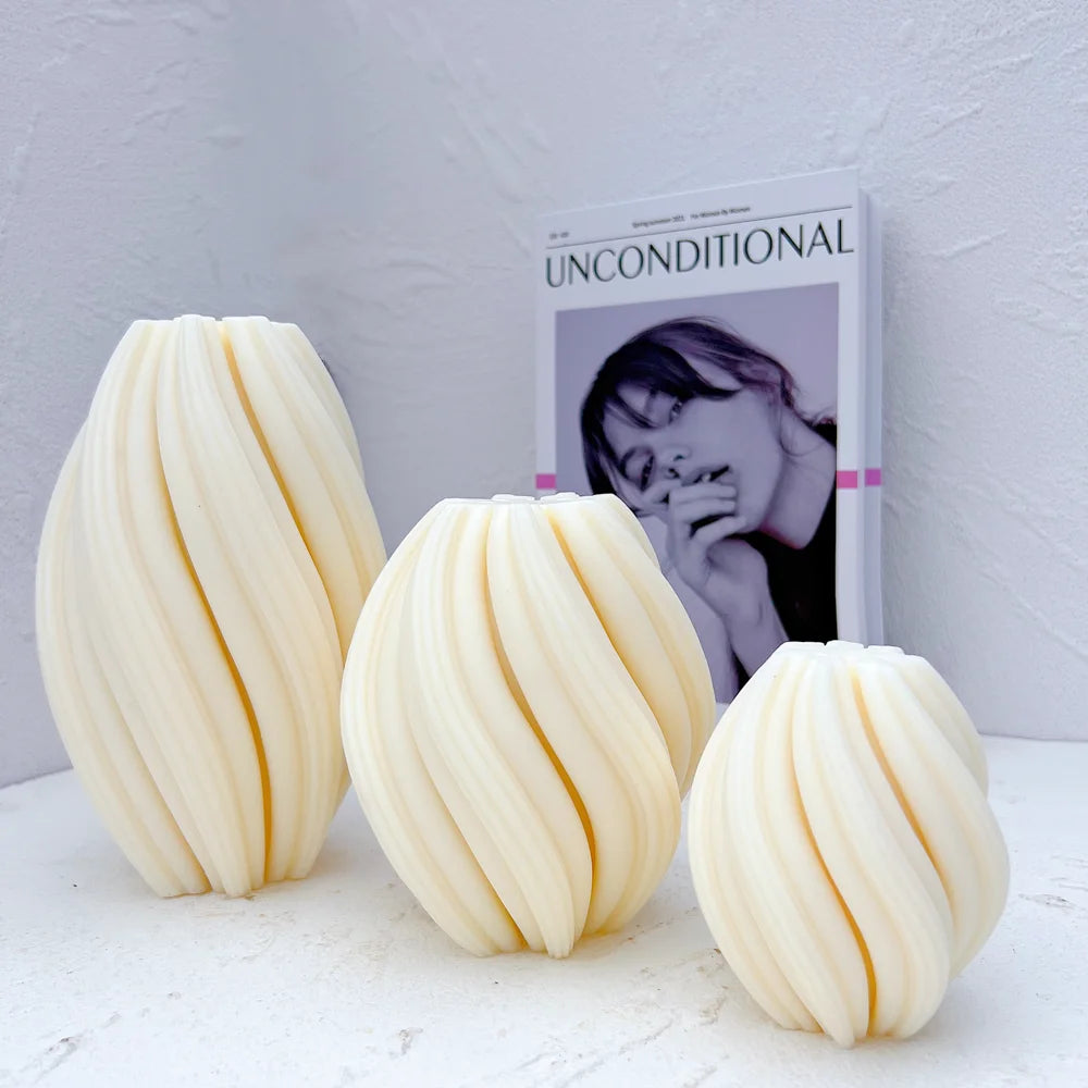 Three ivory twisted-rib oval castings arranged from tall to small