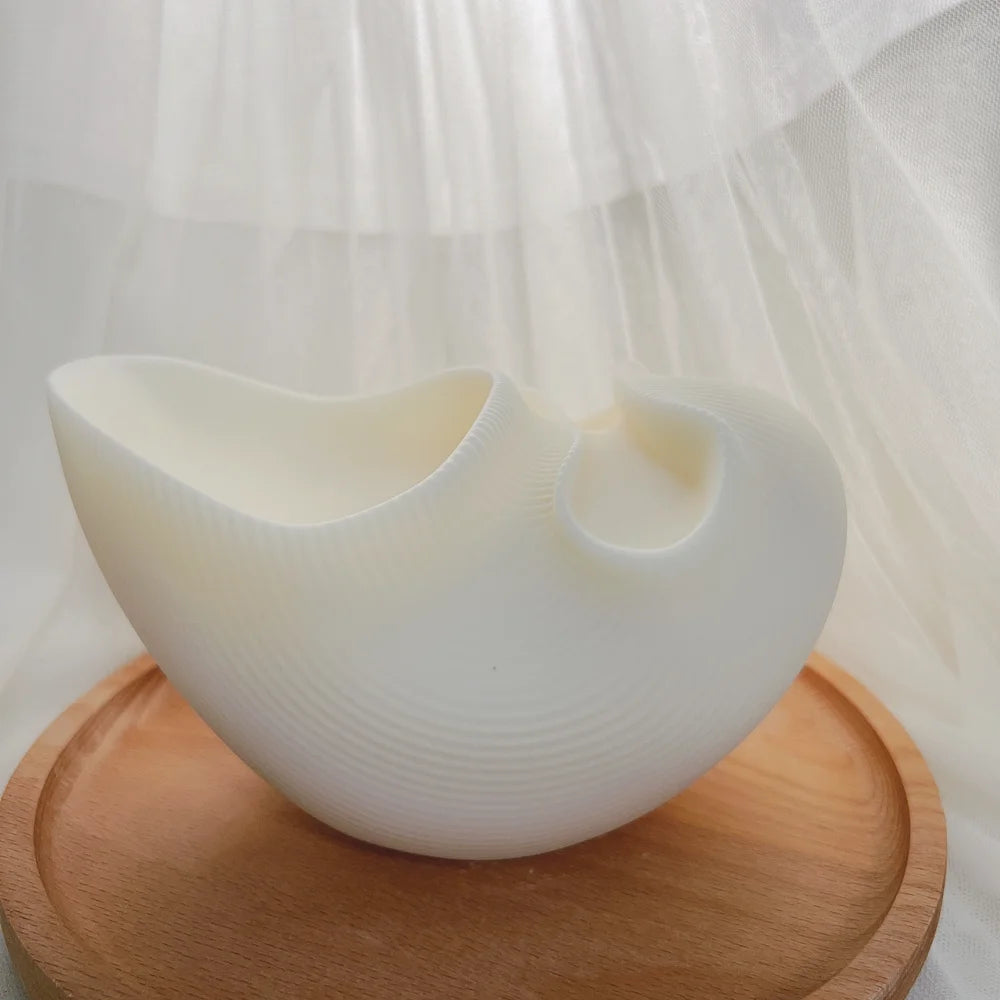 Side view of white double-opening decorative vessel casting on a wooden tray