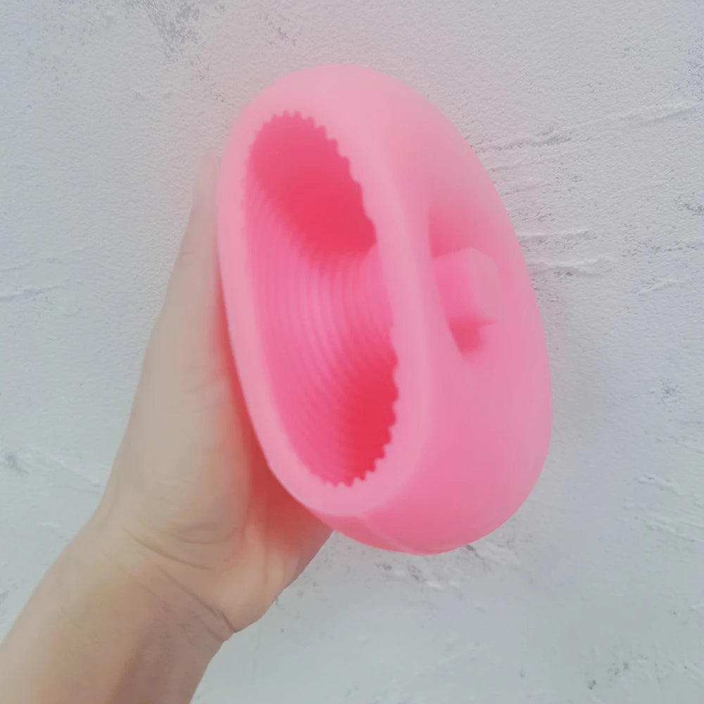 Pink ribbed O letter silicone mold held in one hand