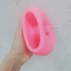 Pink ribbed O letter silicone mold held in one hand