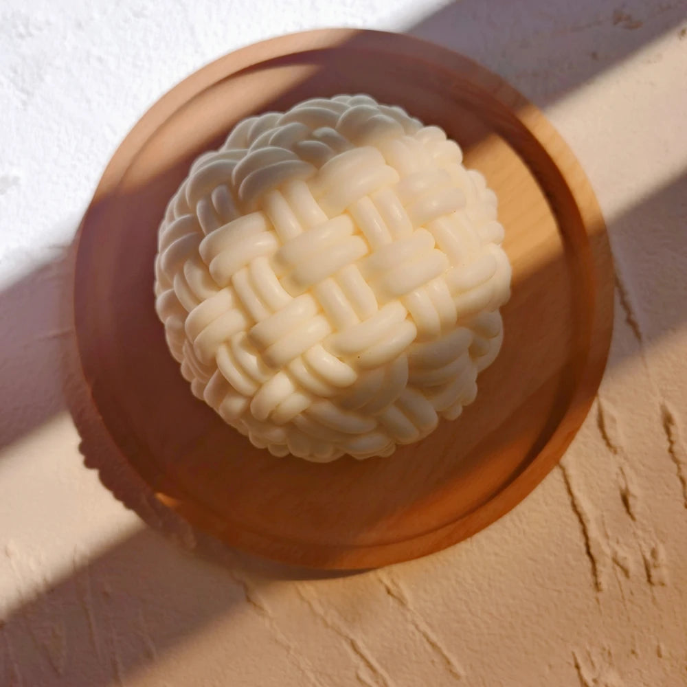 Angled view of interlaced candle bands on a wooden tray