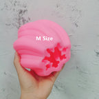 Pink Medium oval mold held to show its twisted rib cavity