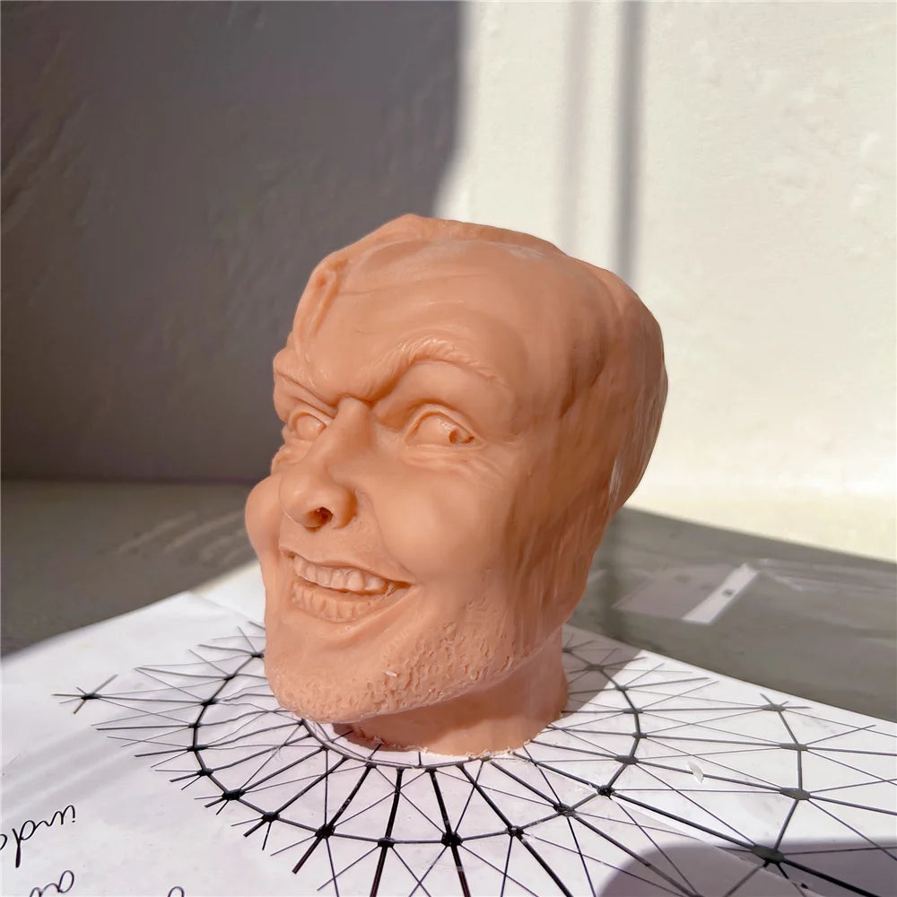 Left-side view of the grinning head sculpture