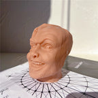Left-side view of the grinning head sculpture