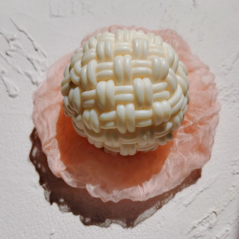 Top view of woven ball casting on a pink display dish