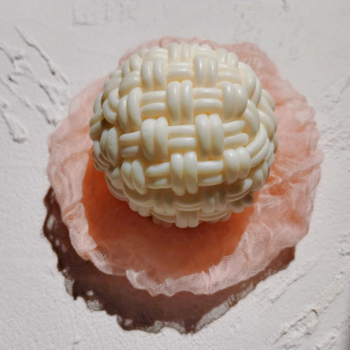 Top view of woven ball casting on a pink display dish