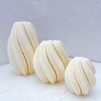 Three ribbed oval castings against a pale textured wall
