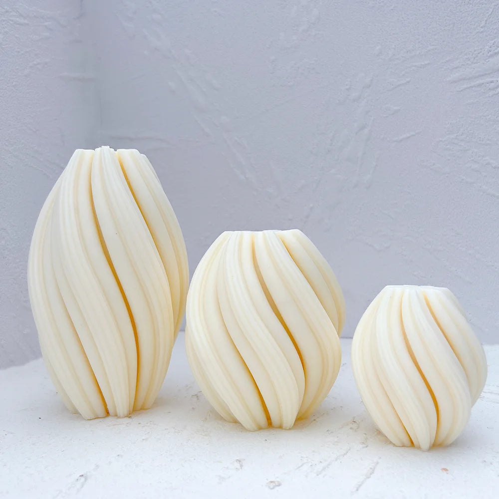 Tall medium and small oval candles with curved diagonal ribs