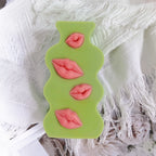 Front view of green plaque with four different lip poses
