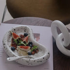Speckled kidney tray staged with food and a utensil