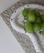 Close-up of a speckled tray casting staged with grapes