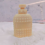 Upright studded bottle casting with decorative neck and cap shape