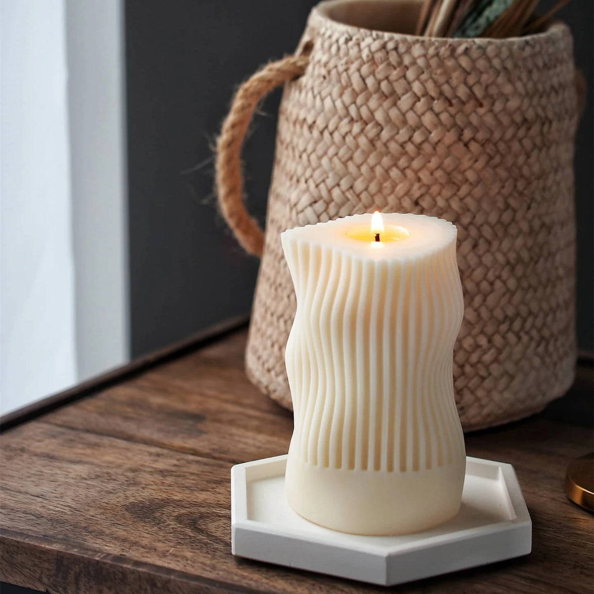 Lit wavy-waist pillar on a small display tray