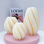 Spiral-rib oval figures in three sizes displayed on a pink round stand