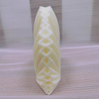 Side view of the same geometric leaf candle showing interlaced raised folds