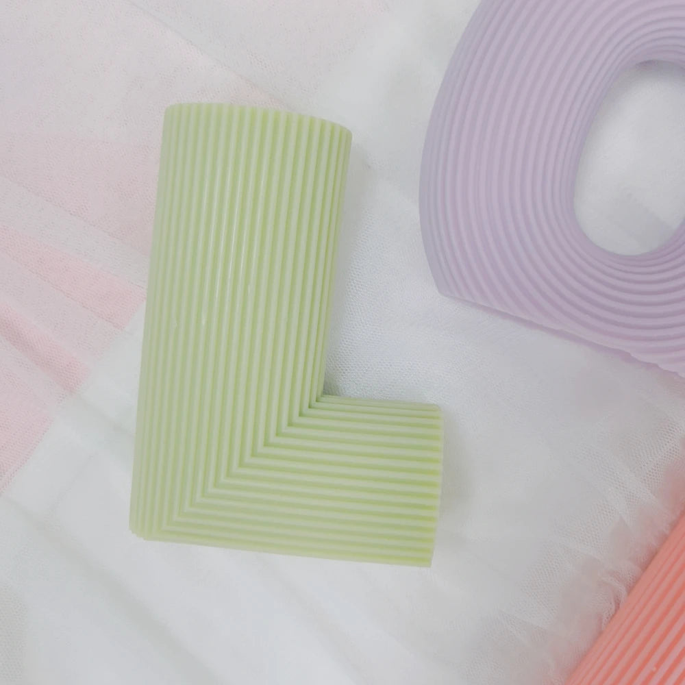 Green L letter casting showing its ribbed face
