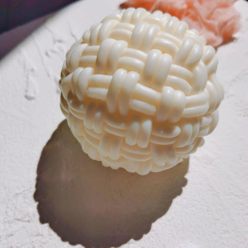 Cream ball candle with thick interlaced basket-weave bands
