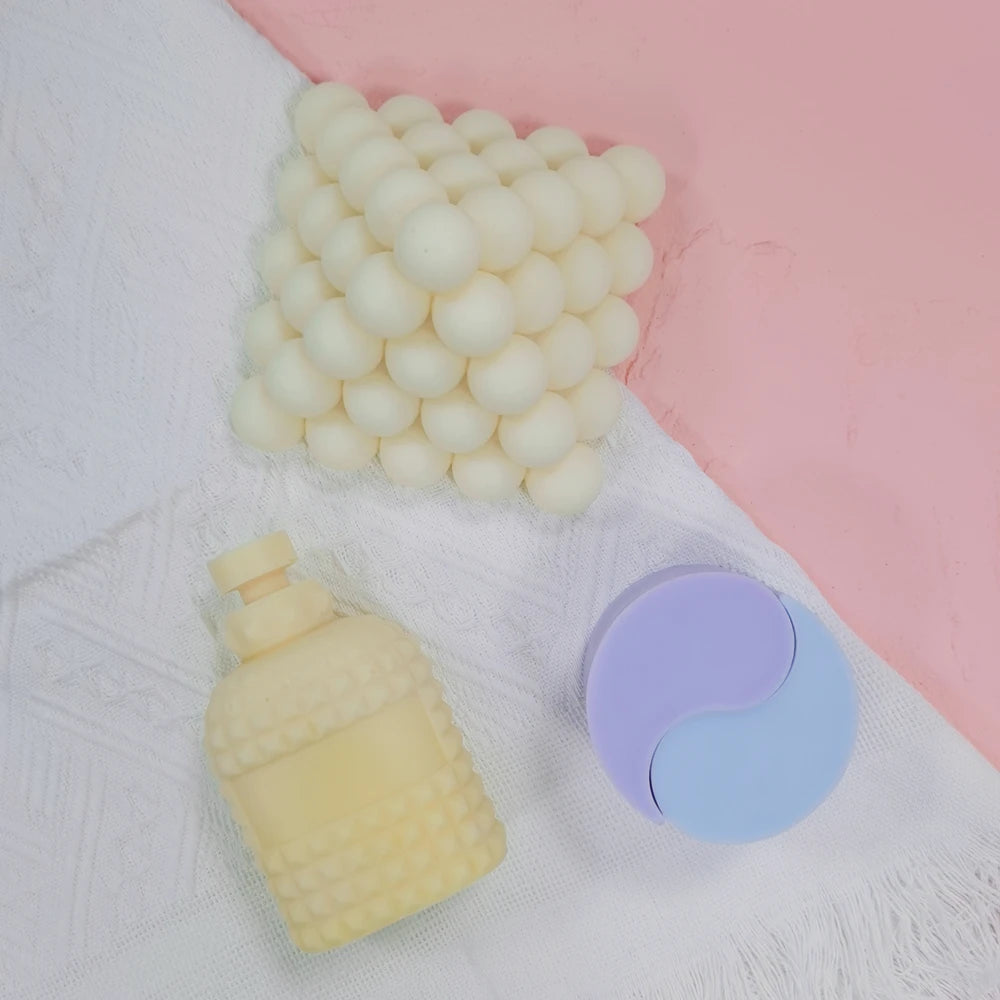 Perfume bottle casting beside a separate bubble figure and purple round prop