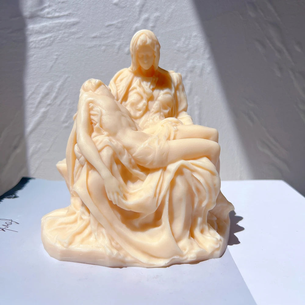 Peach Pietà-style casting of a seated draped figure cradling a reclining figure