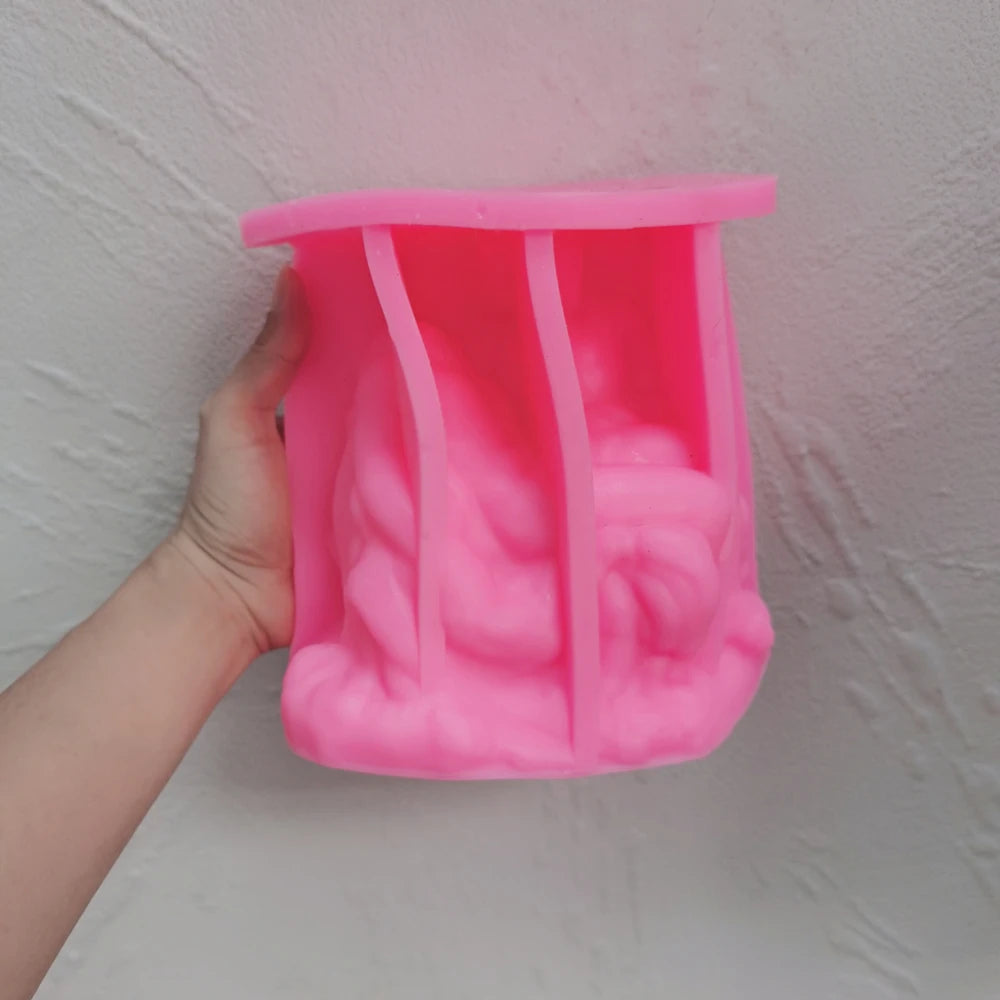 Pink Pietà sculpture silicone mold held in one hand