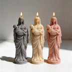 Robed mother cradling infant candle figures in gray cream and peach