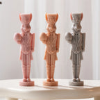 Rabbit nutcracker candles in floral uniforms holding Easter eggs