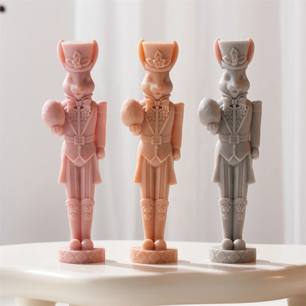 Rabbit nutcracker candles in floral uniforms holding Easter eggs