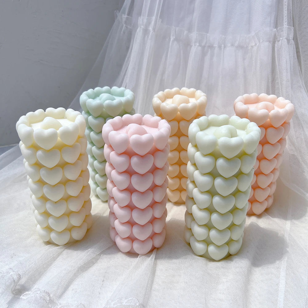 Three textured heart pillar candle castings viewed at an angle