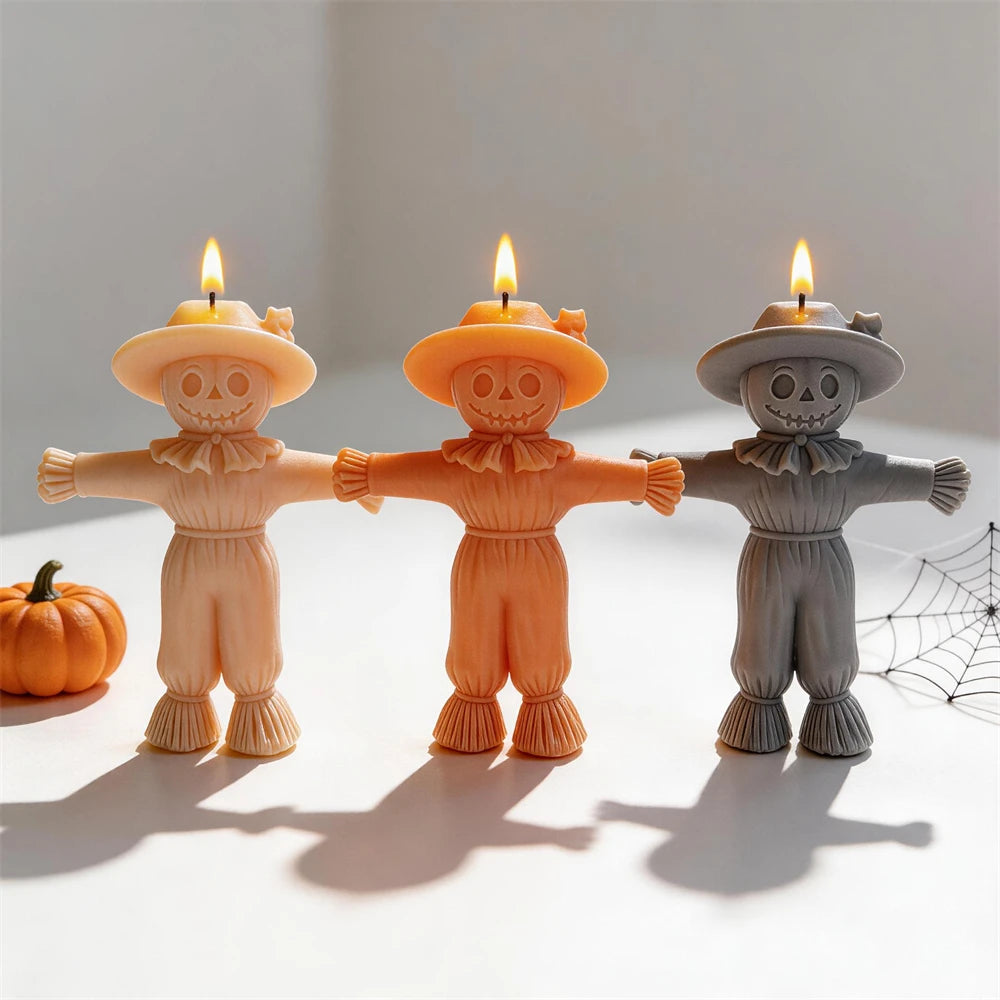Scarecrow candle group arranged with pumpkins and a decorative cobweb