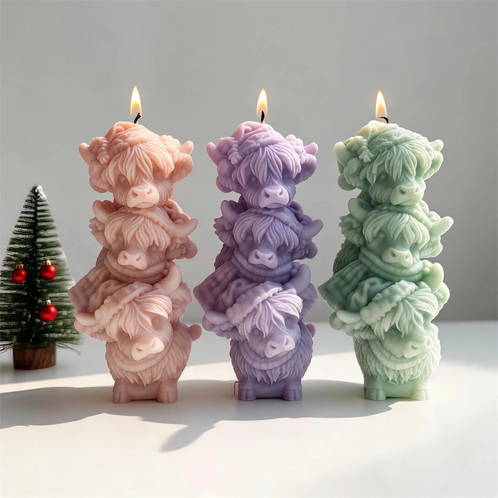Three Highland cow-face stack candles with decorative hair textures