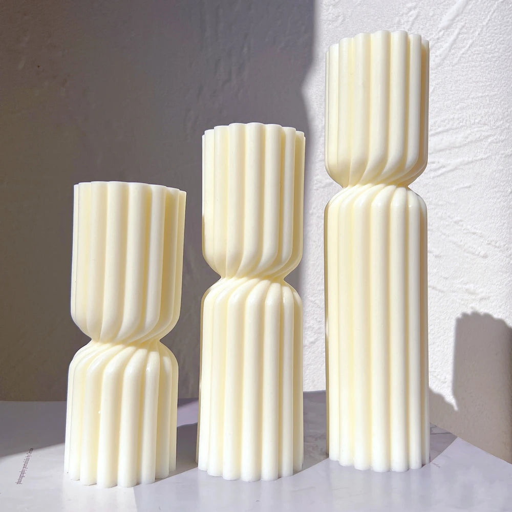 Three ivory fluted double-section pillar candles of different heights