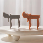 Gray and terracotta Chai-letter candle forms viewed from the side